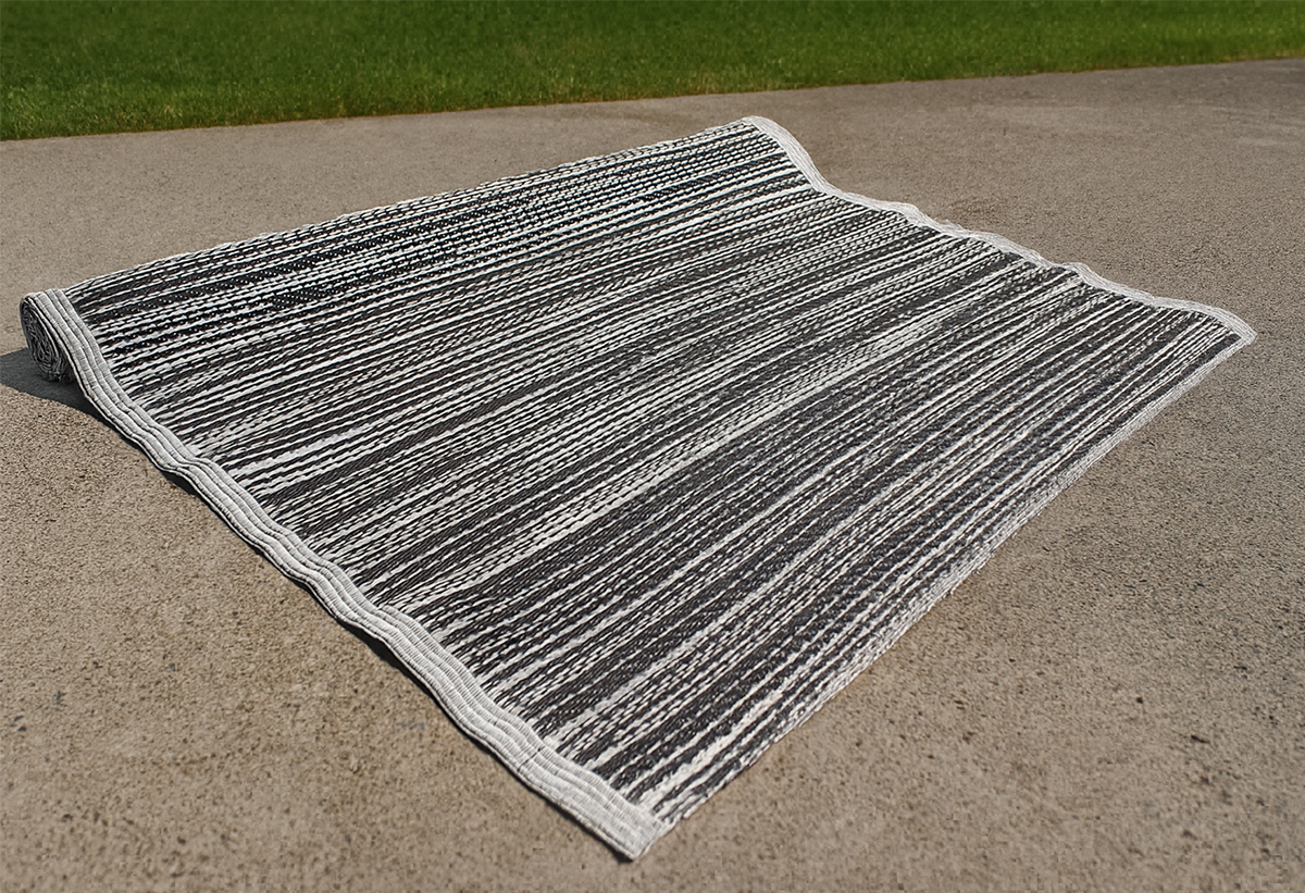 Απεικονίζεται το χαλί απλωμένο στο δάπεδο ενός κήπου.